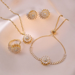 Elegant gold sunflower jewelry set with sparkling crystals on silk background