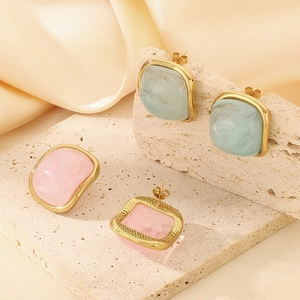 Boucles d'oreilles carrées en résine rose et verte avec bordure dorée sur pierre