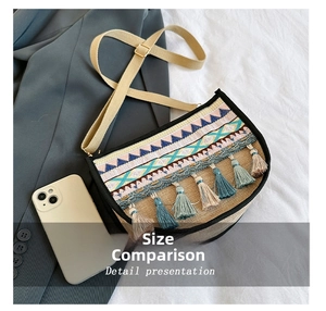 Detail view of ethnic crossbody bag with bohemian patterns and colorful tassels beside a phone