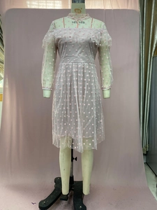Detail of pink polka dot mesh evening dress with ruffled neckline and long sleeves