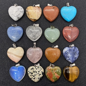 Detailed macro shot of sixteen assorted heart-shaped natural stone pendants with silver clasps