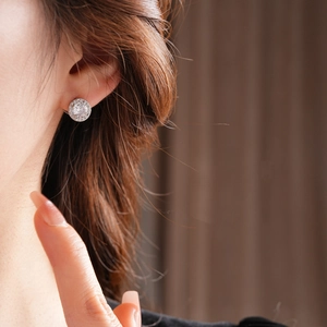 Primo piano di un orecchino a lobo halo in argento con zircone su orecchio modella