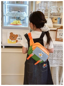 Detailed close-up of a colorful patchwork kids crossbody bag with white flower decoration