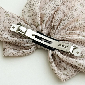 Detail of pink paisley bow clip with CLIP PARIS and HAND MADE engraved on the silver metal