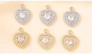 Macro detail of heart-shaped pendants with cubic zirconia in gold and silver finishes