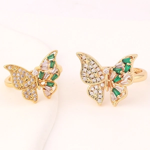 Macro detail of golden butterfly ring featuring green and white zircon crystal inlay
