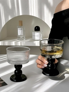 Ribbed texture wine glass featuring unique black spherical base with amber drink detail