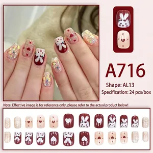 Red and cream press-on nails with rabbit and heart patterns, including glitter finish