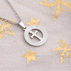 Polished stainless steel cross pendant necklace with white shell inlay on textured fabric