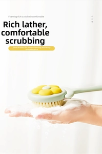 Close-up of mint green bath brush generating rich foam with soft bristles and flower design