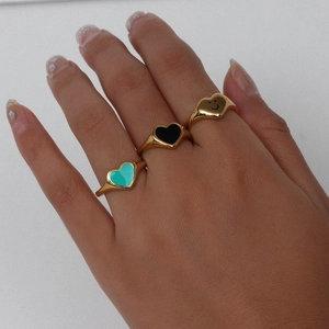 Detailed view of three 18k gold plated stainless steel heart rings with black and turquoise enamel