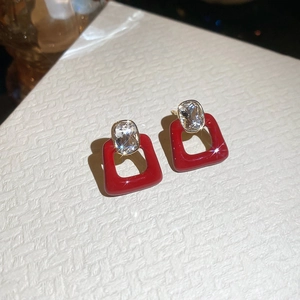 Detail view of red enamel geometric earrings with large oval zircon and gold plating