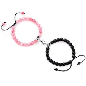 Close-up of magnetic attraction bracelets with pink beads and black matte stone for couples