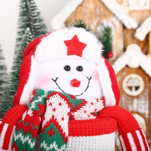 Detail of Christmas snowman candy jar with red knit hat and plush decorative fabric texture