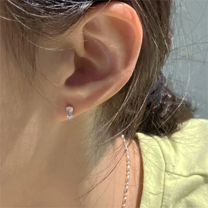 Close-up of minimalist square-cut zirconia silver earring on a model's ear