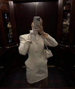 Détails de la robe courte blanche à col montant avec épaulettes et découpes à la taille