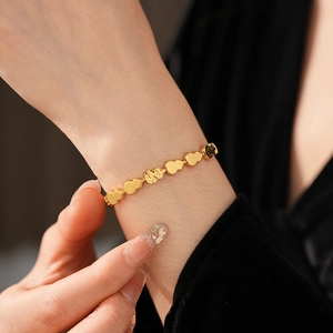Close-up of golden gourd bracelet with polished and hammered textures on a model's wrist