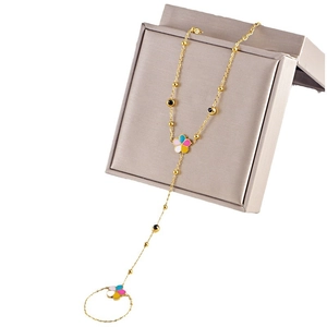 Bracelet bague doré avec fleurs émaillées colorées et perles noires sur boîte grise