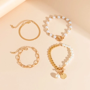 Detail of 4-piece gold chain bracelet set with imitation pearls and vintage links