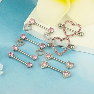 Makroansicht der silbernen Herz-Brustwarzenpiercings mit rosa Zirkon-Inlays