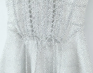 Detailed view of the lace-up corset design on a white polka dot chiffon mini dress
