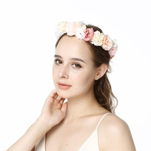 Detail of a pink and beige floral wreath headband worn by a model for weddings