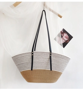 Detail of woven beach tote showing striped texture, khaki bottom and leather straps