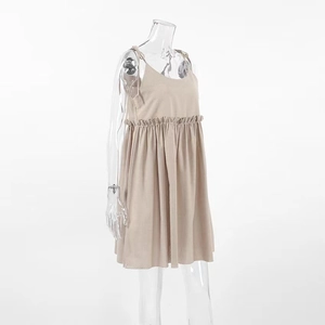 Detail of light khaki cotton linen dress featuring waist ruffle and sleeveless strap design