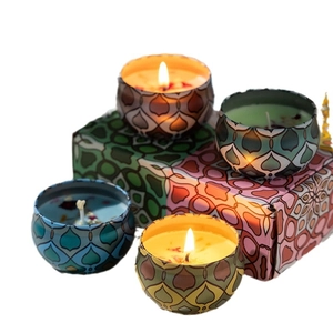 Detailed view of four aromatic candles in metal tins with colorful mandala patterns