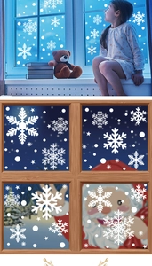 Close-up of white snowflake static window decals applied on glass during Christmas