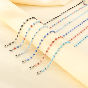 Detailed view of silver evil eye bracelets in various colors on silk fabric