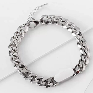 Polished silver titanium steel Cuban link bracelet with plaque on white marble surface
