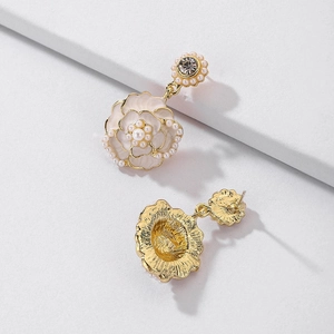 Detail of camellia earrings with white enamel petals, pearls and gold plating back