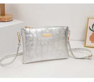 Macro detail of silver crocodile pattern PU leather with elegant golden metal zipper