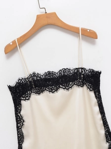 Detailed view of cream satin camisole with delicate black lace trim and silk texture