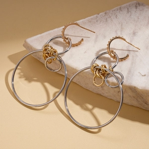 Detail of geometric mixed metal hoop earrings with gold and silver layered rings
