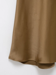 Detail of elegant brown satin dress hemline showing smooth fabric texture and sheen