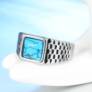 Macro shot of men's silver ring featuring square sky blue stone and textured patterns