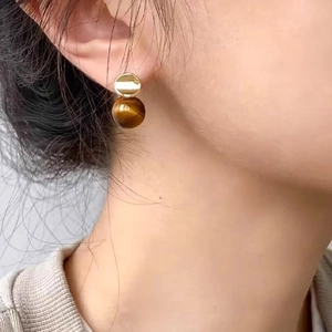 Minimalist 18k gold plated stud earrings with tiger eye stone beads on a female model