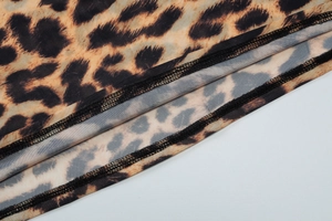 Detail of leopard print mesh fabric texture with high-quality overlock stitching craftsmanship