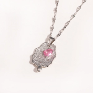 Silver textured hammer-effect necklace with a pink teardrop gemstone on white background