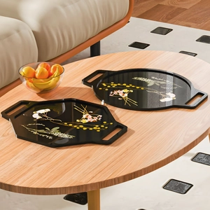 Set of oval and octagonal black resin serving trays with colorful floral patterns
