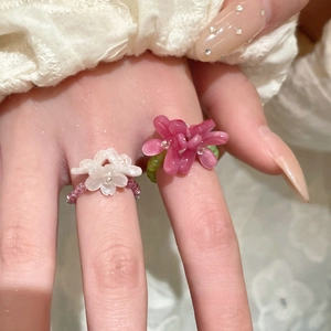 Close-up of handmade beaded flower ring with pink resin petals and white seed beads