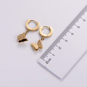 Close-up of gold butterfly earrings with matte texture and size ruler reference