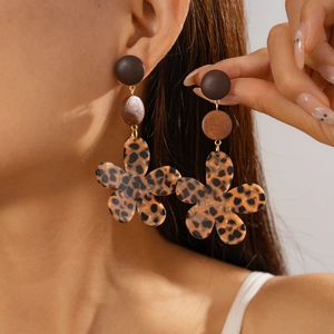 Gros plan d'une femme portant des boucles d'oreilles rétro léopard en résine et bois