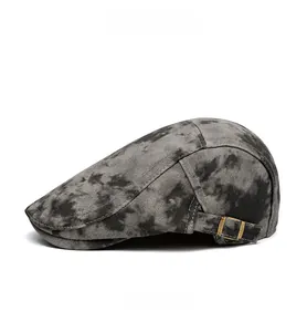 Detail view of the vintage gray tie-dye flat cap featuring an adjustable bronze buckle