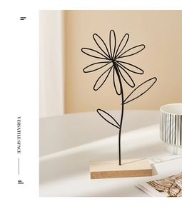 Detail of Nordic iron flower ornament with black wire daisy and natural wood base