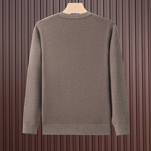 Detailstruktur der dunkelbraunen Strickjacke mit Rippbündchen am Holzkleiderbügel
