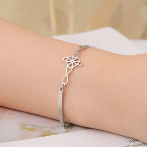 Minimalist silver stainless steel bracelet featuring a hollow geometric Celtic knot design