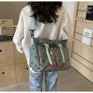Rear view of a large floral tote bag with cherry prints and light green straps